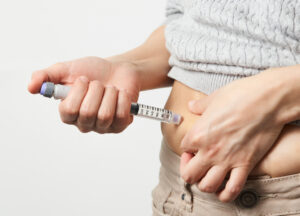 Foto einer Person mit Abnehmspritze am Bauch