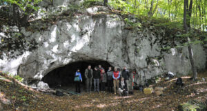Foto der Forschenden vor dem Eingang zur Maszycka Höhle in Polen