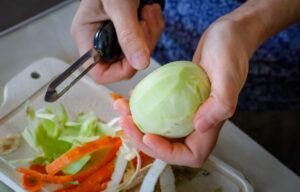 Foto einer Person, die eine Kohlrabi schält