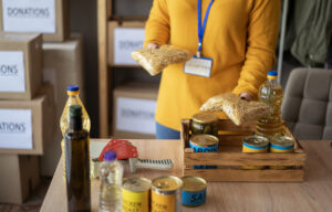 Freiwilliger packt Kisten mit Lebensmittelspenden