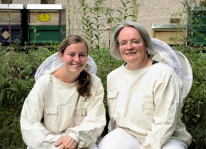 Foto von den Bienenexpertinnen Julia Dittes und Ilka Emmerich in Imkerkleidung