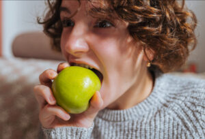 Foto eines Jungen, der in einen Apfel beißt