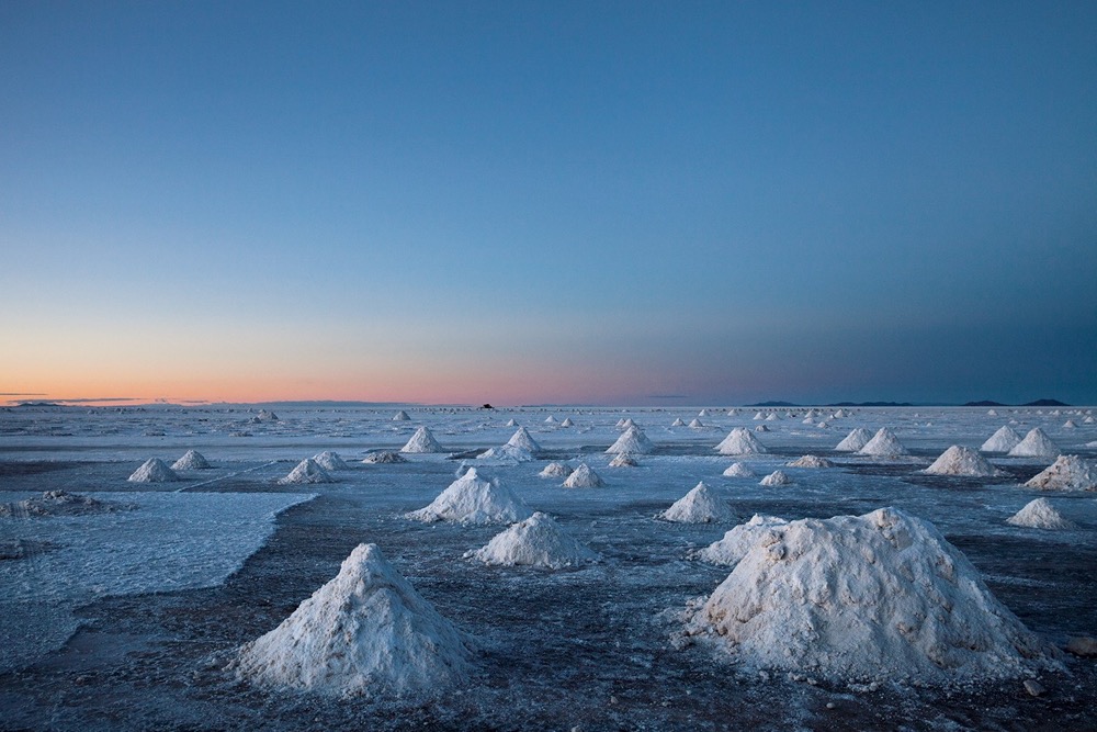 Das Salz in der Salar de Uyuni steht knapp unterhalb der Oberfläche an. Es wird abgegraben und zum Trocknen aufgehäuft. Neben Salz wird hier auch Lithium abgebaut, das für Akkus gebraucht wird. (Foto: © Luke Duggleby / Landa-Ochandiano arquitectos)