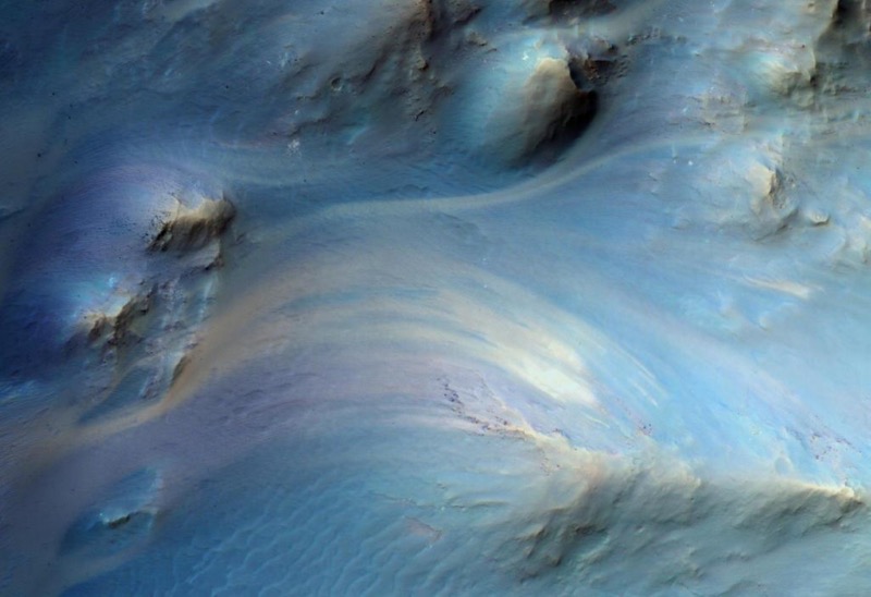 Das Zentrum eines Einschlagkraters: Die verschiedenen Farbstreifen markieren unterschiedliche Gesteinsschichten, die der Einschlag freigelegt hat. (Foto: NASA/JPL-Caltech/University of Arizona/HI-RISE team)