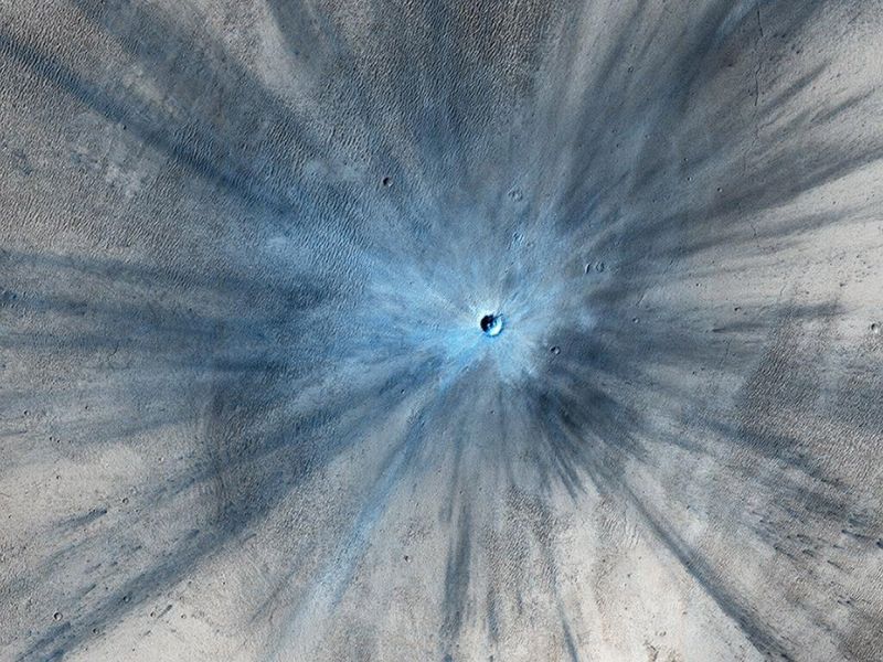Nach einem Meteoriteneinschlag: Dieser Krater hat einen Durchmesser von etwa 30 Metern und ist von einer großen Explosionszone umgeben. (Bild ©  NASA/JPL-Caltech/University of Arizona)