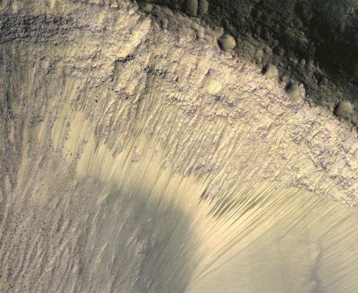 Die Ursache dieser sich mit den Jahreszeiten verändernden dunklen Streifen an einigen Kraterhängen war lange umstritten: Fließt hier womöglich Salzwasser? Inzwischen gehen Forscher eher davon aus, dass hier dunkler Sand abrutscht. (Bild ©  NASA/JPL-Caltech/University of Arizona)