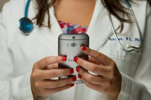 Medizinerin mit Smartphone in den Händen